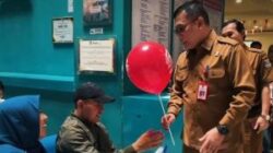 Bangkitkan Rasa Nasionalisme, Kepala Disdukcapil Kab. Tangerang Bagikan Bendera Merah Putih Ke Warga Pemohon Adminduk